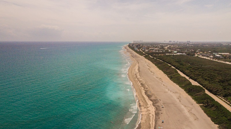Dynamic Aerial View of Juno Beach, Florida at Mid-Day During Spring Break in March of 2021